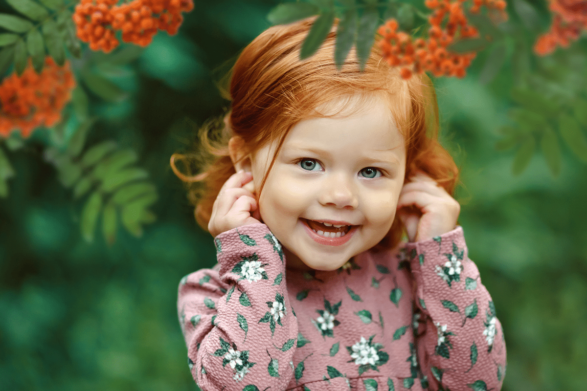 Маленькая рыжая девочка улыбается