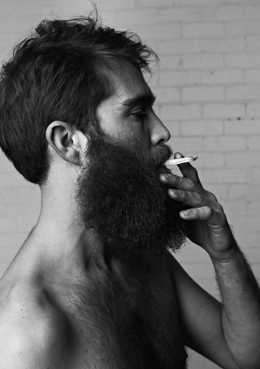 Бородатый мужчина курит