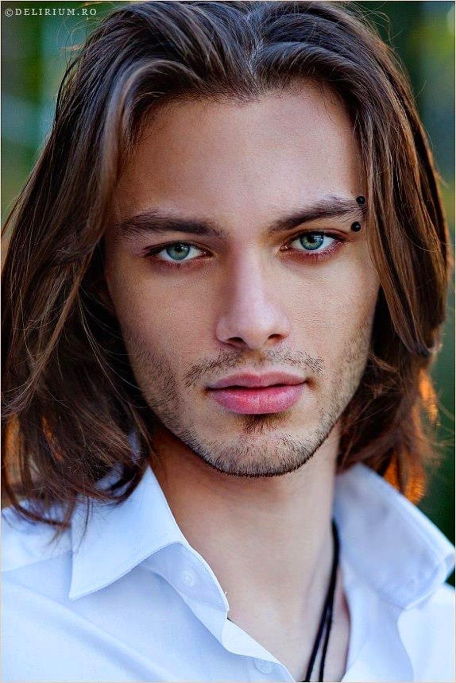 Мужчина с длинными каштановыми волосами