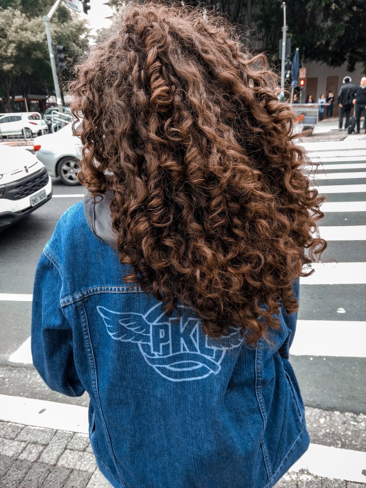 Девушка с кудрявыми волосами со спины