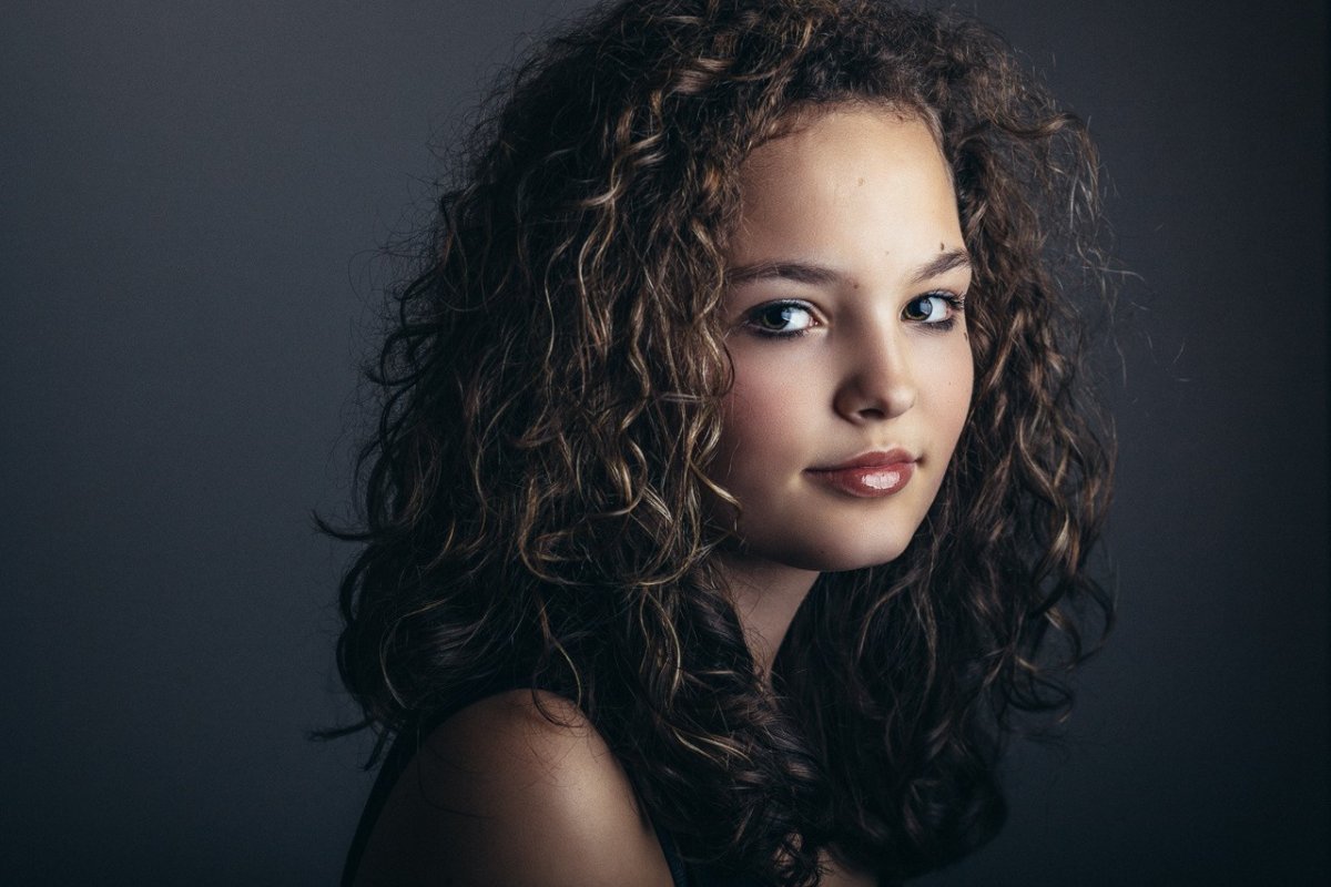 Фото красивой девушки с узкими темными глазами и кудрявыми волосами