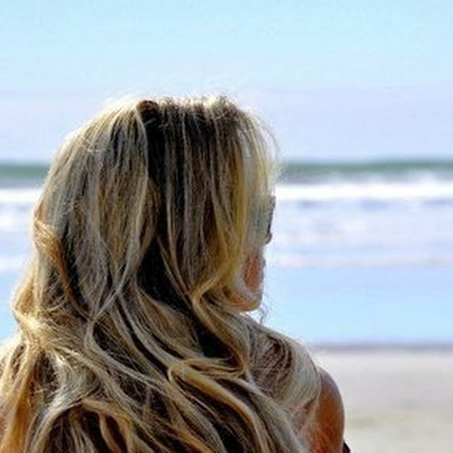 Девушка с мелированными волосами со спины на море
