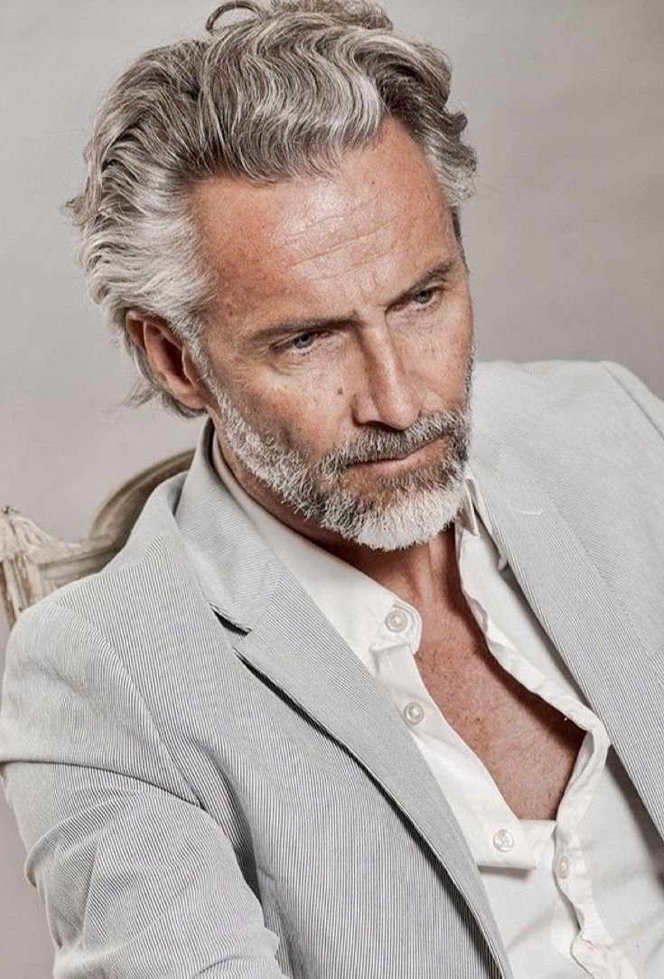 Пожилой мужчина с длинными волосами в костюме