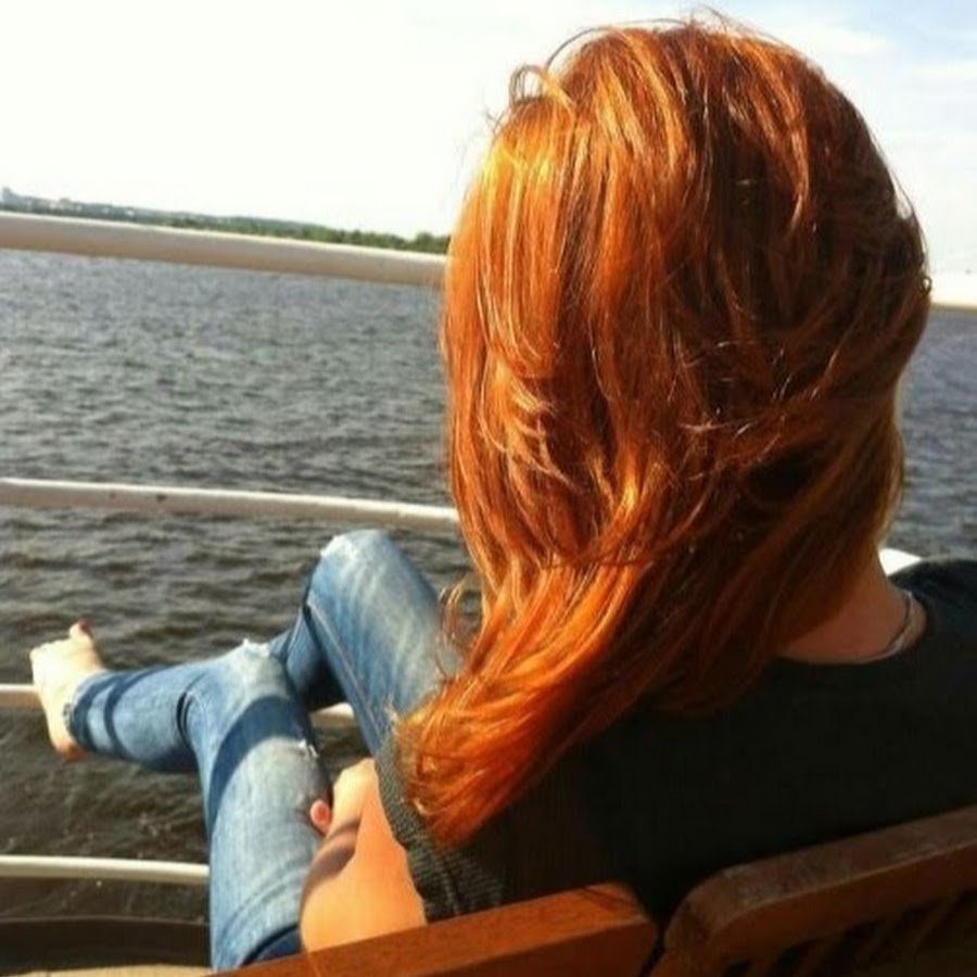 Рыжая девушка на море со спины