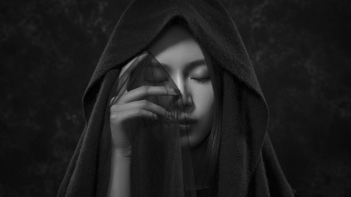 Женщина в черном капюшоне